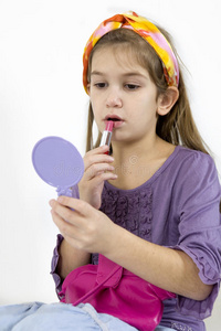 可爱的女孩化妆照镜子.照片