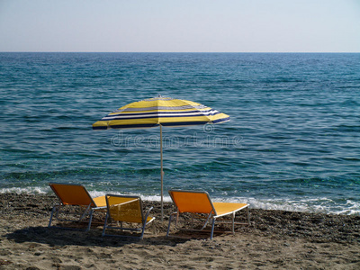 沙滩上的雨伞和三张日光浴床