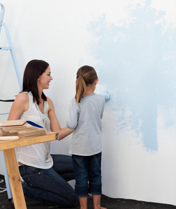 母亲和女儿在墙上画画
