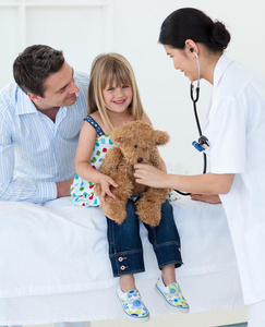 医生和小女孩在检查泰迪熊