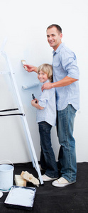 父亲和儿子用刷子粉刷房间