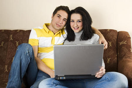 夫妻俩在沙发上用笔记本电脑