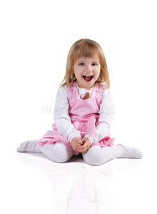可爱的小女孩穿着粉红色的盘腿坐着