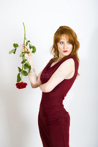一个迷人的优雅的女人，穿着带玫瑰的红色连衣裙