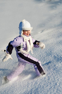 风趣的小女孩在雪地里奔跑