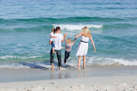 快乐的一家人走在沙滩上图片