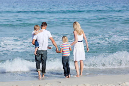 幸福的一家人走在沙滩上图片