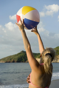 海滩上穿着比基尼玩沙滩球的女人