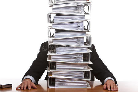 坐在办公室里拿着大量文件的商人照片