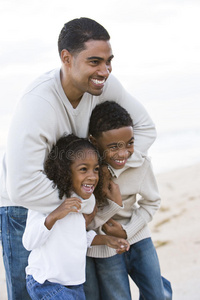 非洲裔美国人的父亲和两个孩子在海滩上