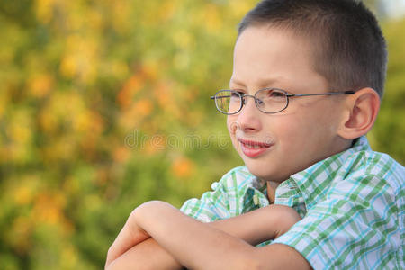 秋天公园里双臂交叉的男孩的画像
