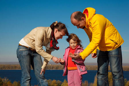 女孩在秋天和父母一起玩大自然
