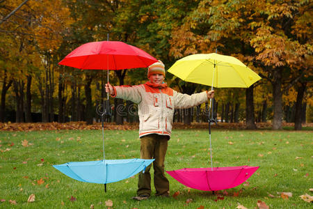 公园里的男孩控制着四把雨伞