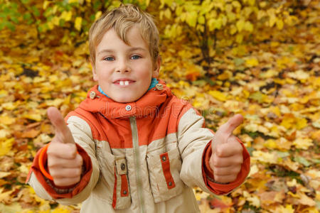 秋天公园里的男孩靠着落叶