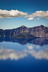 云在火山口湖清澈的蓝色水中反射