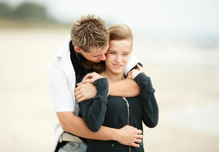 年轻夫妇在沙滩上接吻