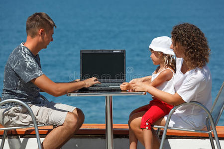 一家人坐在桌旁拿着笔记本电脑图片