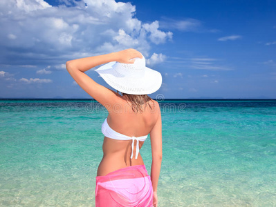 戴帽子的女人站在海滩上