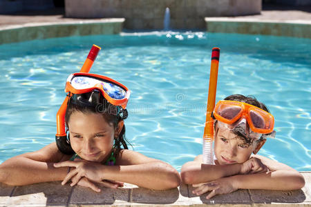 带护目镜和浮潜器的游泳池男孩和女孩