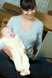 母亲婴儿和笔记本电脑