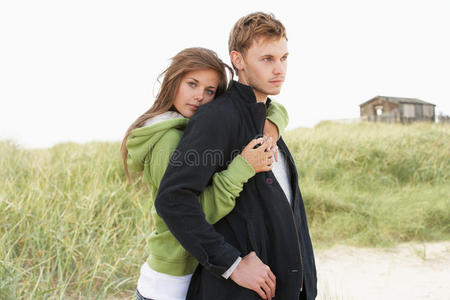 站在沙丘边的浪漫年轻夫妇