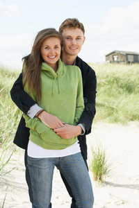 站在沙丘边的浪漫年轻夫妇图片
