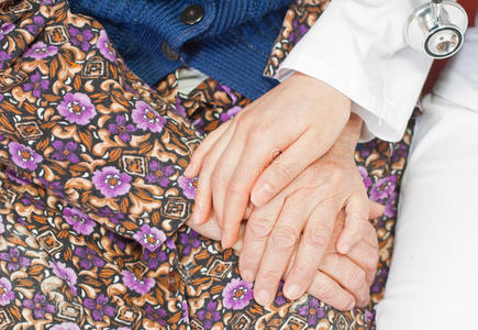 年轻可爱的医生握着老妇人的手