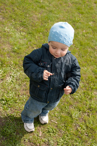 小男孩在春天的草地上散步