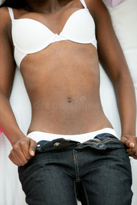 一位非洲妇女脱掉牛仔裤的特写镜头