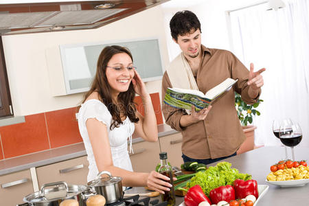 幸福夫妻用菜谱在厨房做饭图片