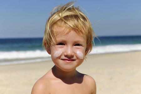 海滩上涂着防晒霜的可爱孩子