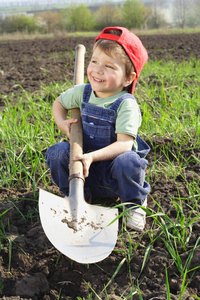微笑的小男孩拿着大铲子