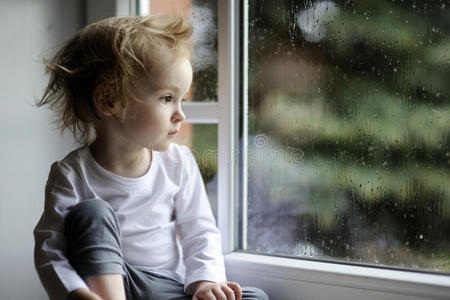 可爱的小女孩看着雨滴