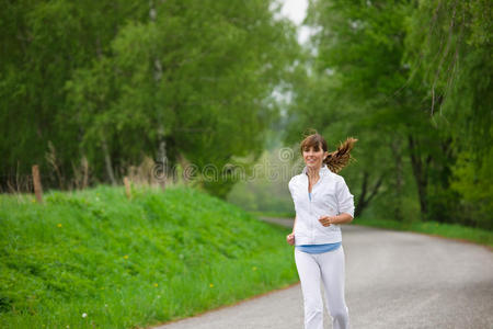 慢跑运动型女性在自然道路上奔跑