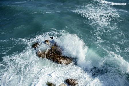汹涌的海浪冲向巨石图片