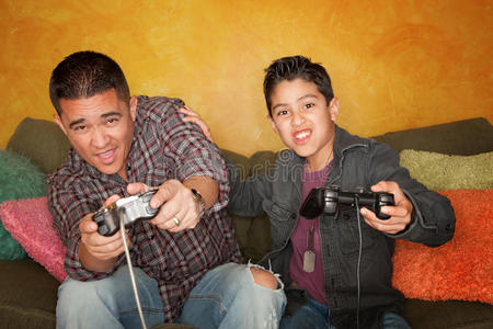 西班牙裔男子和男孩玩电子游戏