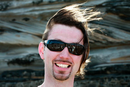 一个留着风吹的头发戴着太阳镜的男人照片