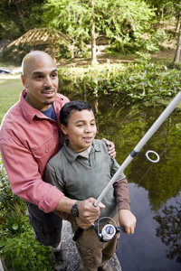 西班牙裔父子在池塘钓鱼