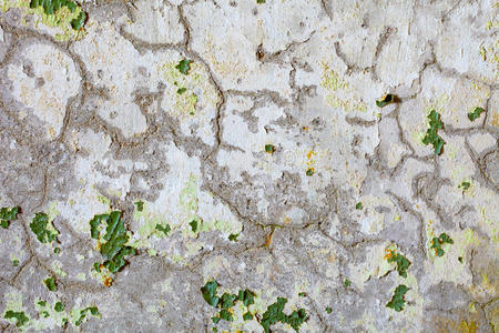 旧灰泥上绿色油漆的裂缝和斑点