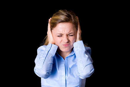 年轻女性捂住耳朵不让噪音,情绪影响照片