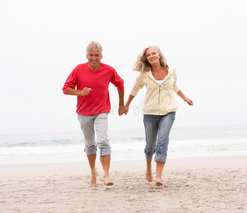 长辈夫妇在沙滩上跑步度假