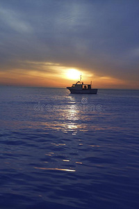 日落日出渔船在地平线上