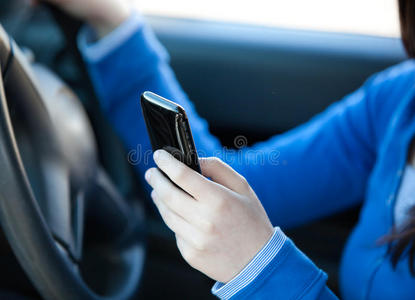 一个青少年在车里发短信的特写镜头
