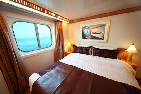 带床和窗的船舱，可看到海景