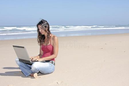一个年轻漂亮的女人在她的笔记本电脑上工作