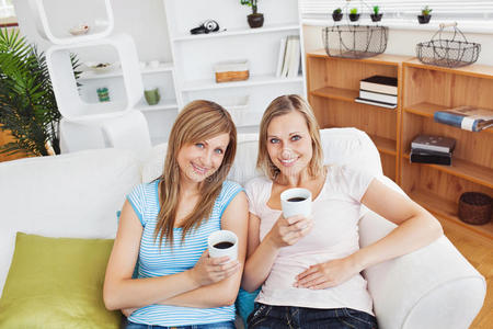 放松的两个女人微笑着喝着咖啡