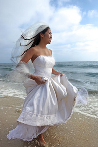 快乐的新娘在海边漫步