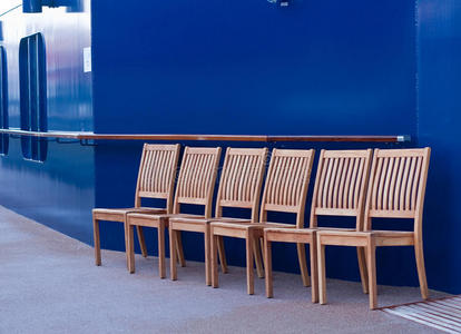 六把木椅在蓝墙边的甲板上