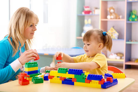 教师和学龄前儿童玩建筑砖