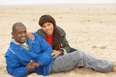 年轻夫妇在冬季海滩度假时放松